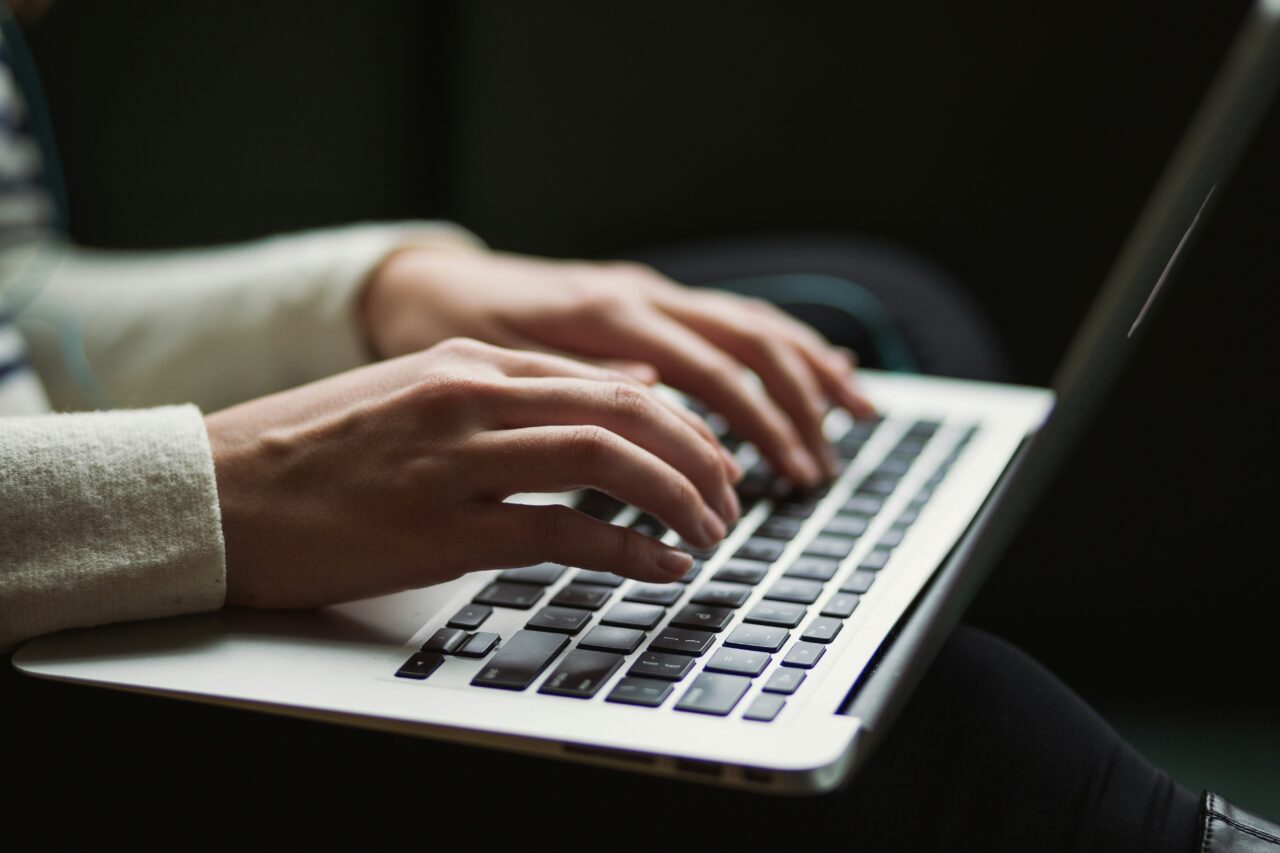 A person types on their laptop
