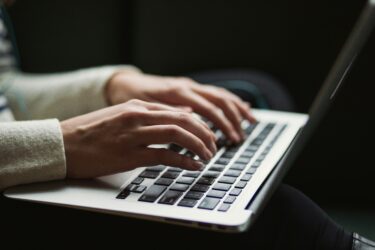 A person types on their laptop