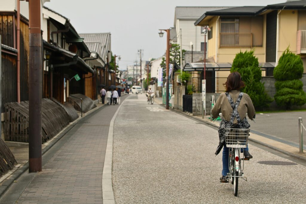 A woman rides her bike down the streets of Kyoto